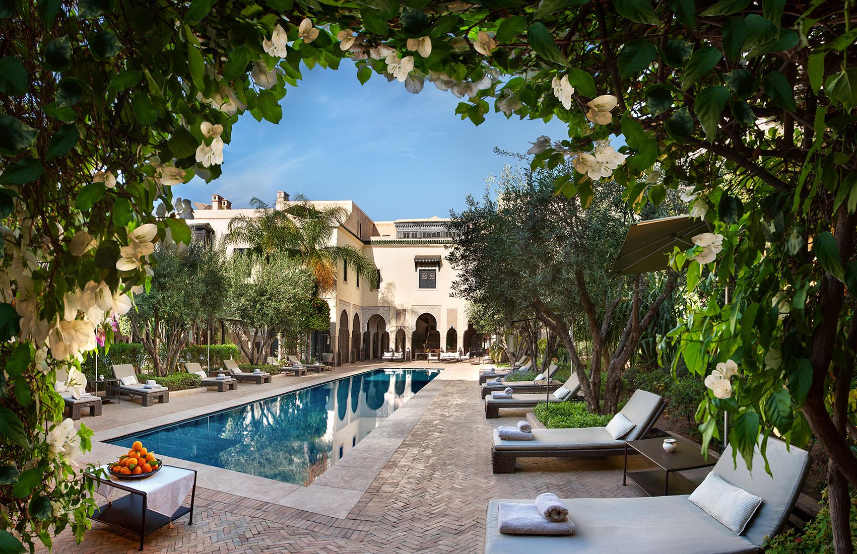 A serene poolside at La Villa des Orangers, adorned with lush greenery and loungers