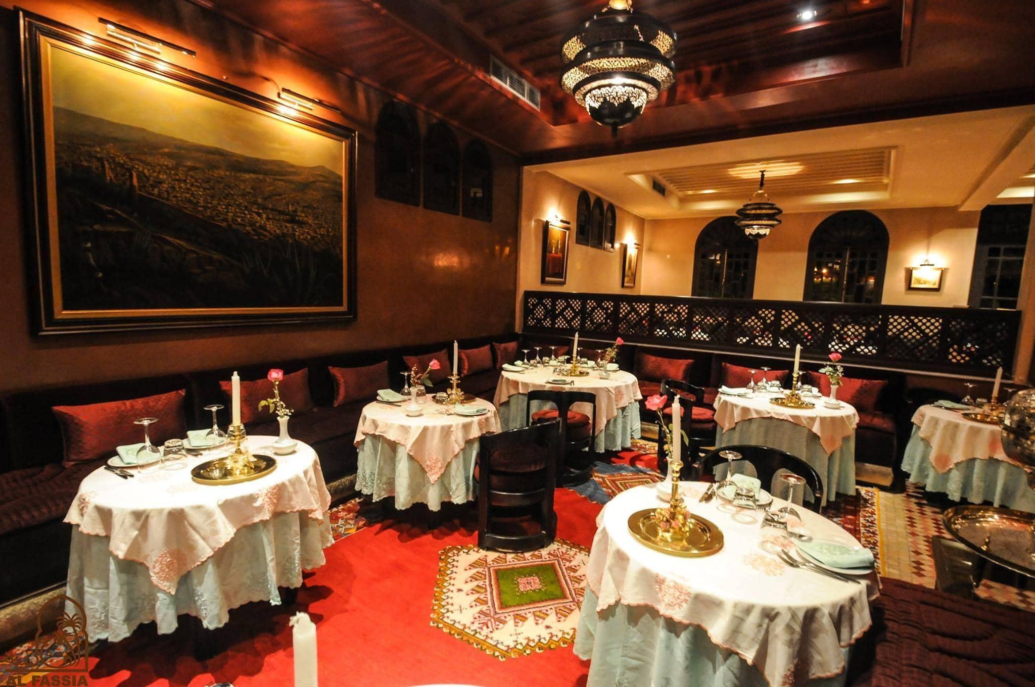 A charming and intimate dining room at Al Fassia in Marrakesh, featuring traditional Moroccan decor, cozy seating, and elegantly set tables with candlelight.