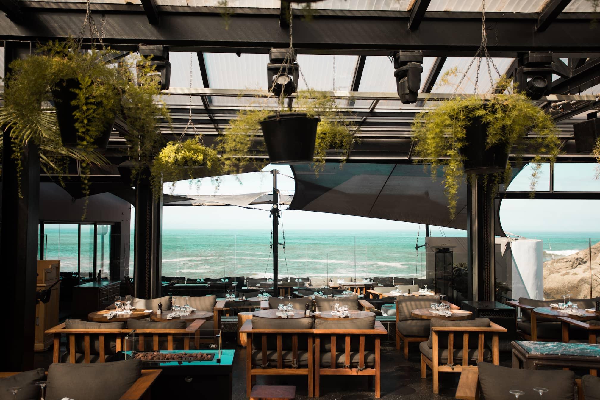 A stylish and modern dining area at Le Cabestan in Casablanca, offering stunning ocean views and a chic, relaxed atmosphere.